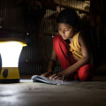 Una niña lee en su casa utilizando una luz de energía solar en Jaliyapalong, Cox's Bazar, Bangladés.